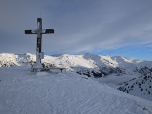 Das Gipfelkreuz des Kleinen Gamsstein mit dem Skigebiet im Hintergrund