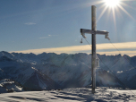 Das Gipfelkreuz am Juifen mit dem Karwendelgebirge im Hintergrund